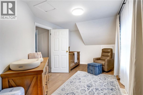 Nursery with dresser, crib, recliner chair, ottoman, and area rug - 23247 Beattie Drive Elgin