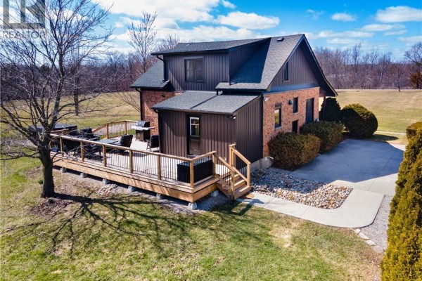 House exterior with large wooden deck, grill, outdoor seating - 23247 Beattie Drive Elgin