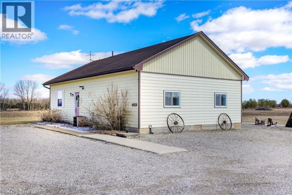 House with beige siding, pink door, and wagon wheels - 23247 Beattie Drive Elgin