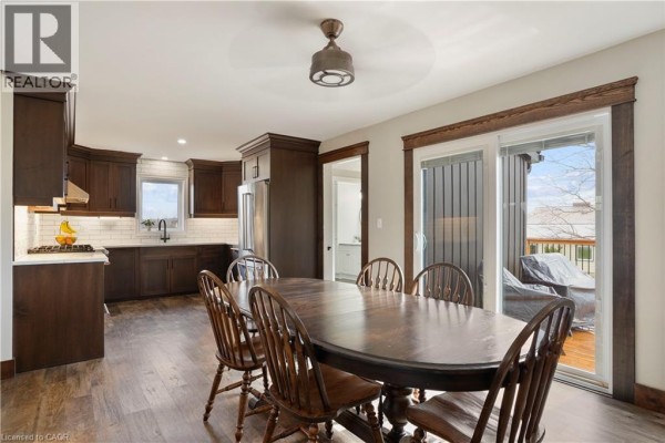 Dark wood dining table and chairs with kitchen view & sliding doors to deck - 23247 Beattie Drive Elgin