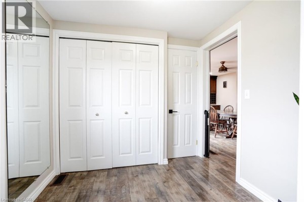Hallway with bi-fold closets, mirror, and view to dining room - 23247 Beattie Drive Elgin