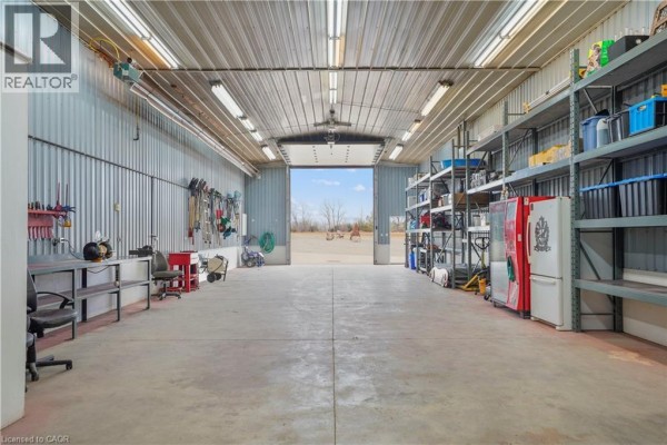 Spacious garage with large overhead door, shelving, workbenches & refrigerators - 23247 Beattie Drive Elgin