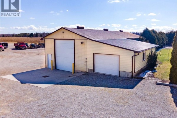 Commercial building with two garage doors and yellow siding - 23247 Beattie Drive Elgin