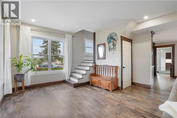 Living room with bench, staircase, and large window - 23247 Beattie Drive Elgin