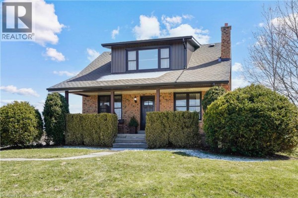 Living room with large sectional sofa, ottoman, and large windows. - 23247 Beattie Line, Elgin