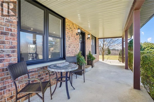 Dining area with wooden table and chairs in front of built-in wet bar. - 23247 Beattie Line, Elgin