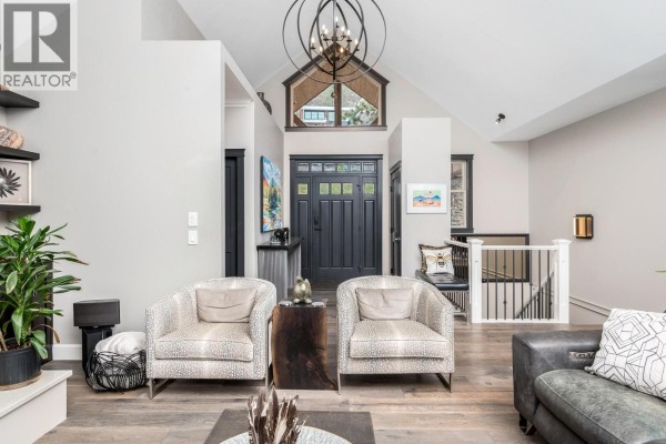Interior living area with modern furniture, high ceilings, and large windows for natural light. - 2328 Arthur Court, Kelowna