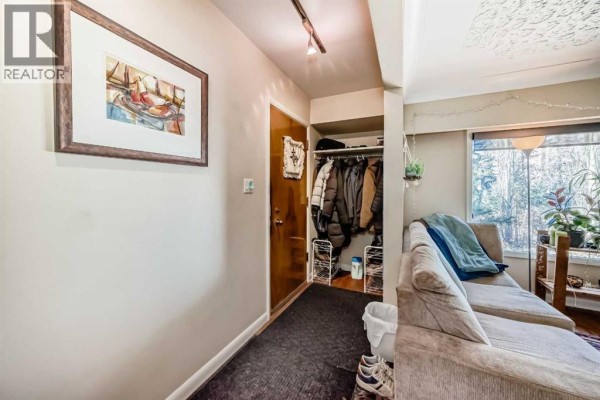 Interior entryway with a coat rack filled with clothes, shoe rack, and a framed picture on the wall. - 2328 Capitol Hill Crescent Nw, Calgary