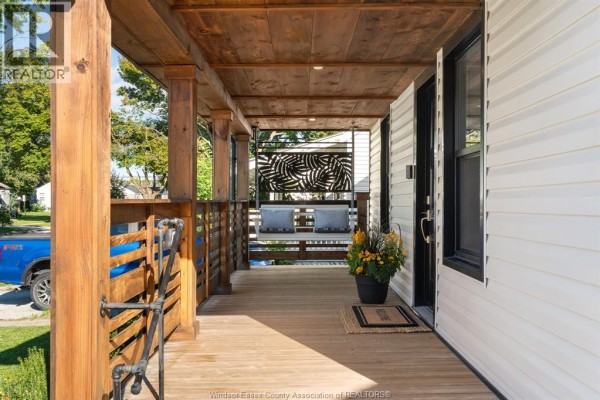 View of a wooden porch with a swing, featuring wooden posts and siding. - 2328 Forest, Windsor