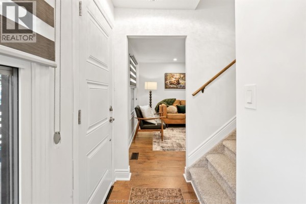 Interior hallway looking towards a living room with a sofa and armchair. - 2328 Forest, Windsor