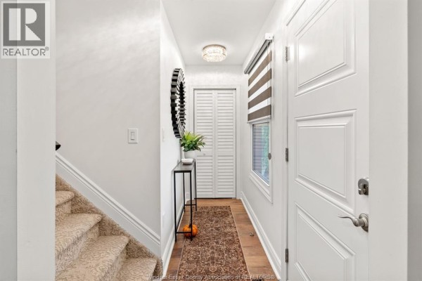 Interior hallway with a staircase, white doors, and a decorative mirror. - 2328 Forest, Windsor