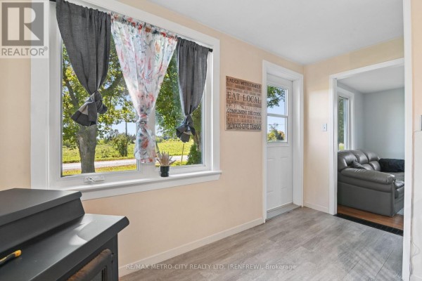 Interior view of a room with a large window, gray curtains, and a door. - 2328 Kerr Line, Whitewater Region
