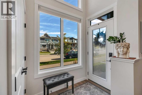 Interior view of the entryway with a bench, door, and large window overlooking the street. - 233 Haskayne Drive Nw, Calgary