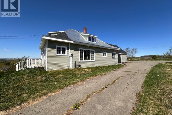 Exterior view of a light green vinyl-sided building with a dark asphalt shingle roof and white trim. - 233 Hilldale Road, New Denmark