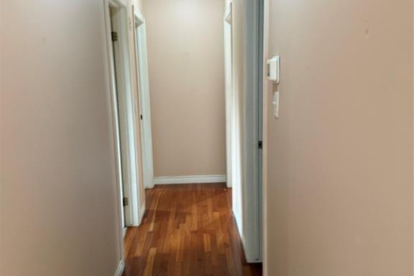 Hallway with hardwood floors, beige walls, and doors leading to rooms on both sides. - 2337 Askin, Windsor