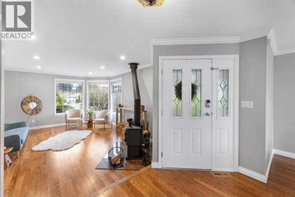 Entryway featuring double doors, wood stove, and hardwood flooring - 23390 123 Avenue, Maple Ridge