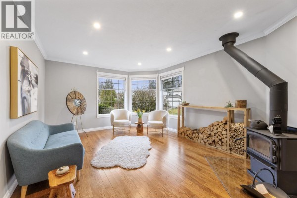Cozy living area with bay windows, wood stove, and modern furnishings - 23390 123 Avenue, Maple Ridge