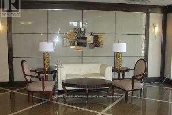 Building lobby seating area with a white sofa, two chairs, and two side tables. - 234 - 18 Harding Boulevard E, Richmond Hill