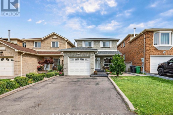 Front exterior of a two-story detached house with light brick facade, garage, and green landscaping. - 234 Lech Walesa Drive, Mississauga