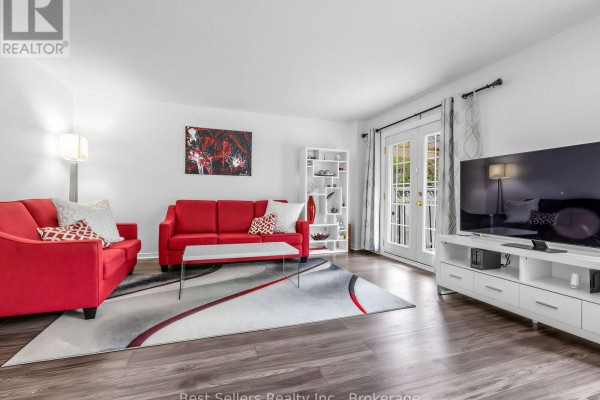 Open concept living area featuring a white kitchen with light gray floors and adjacent living room. - 234 Lech Walesa Drive, Mississauga