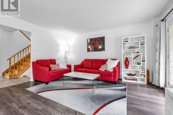 View down a narrow white kitchen with stainless steel appliances and a view into a dining area. - 234 Lech Walesa Drive, Mississauga
