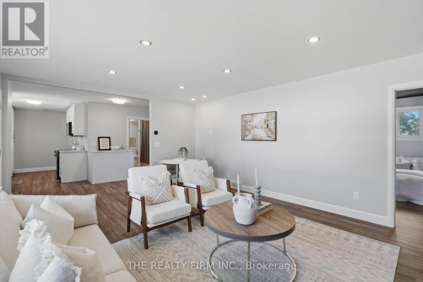 Open-concept living room and kitchen area with a doorway leading to a bedroom on the right. - 234 West Street, Central Elgin