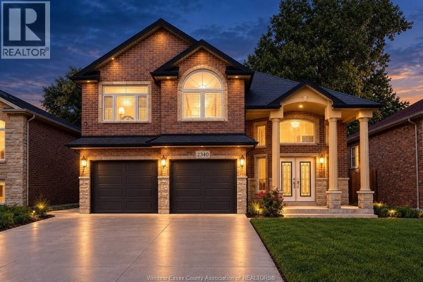 Exterior view of a large brick house with a paved driveway. - 2340 Rankin Avenue, Windsor