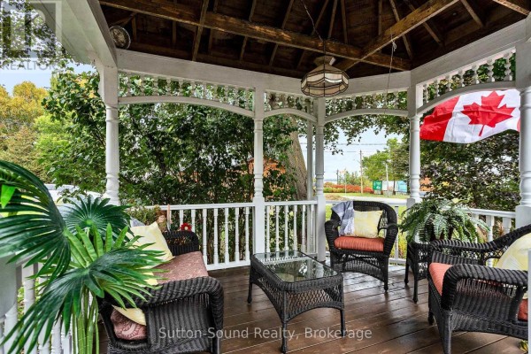 Close-up of the gazebo seating area with wicker furniture and a Canadian flag. - 2344 3rd Avenue, Owen Sound