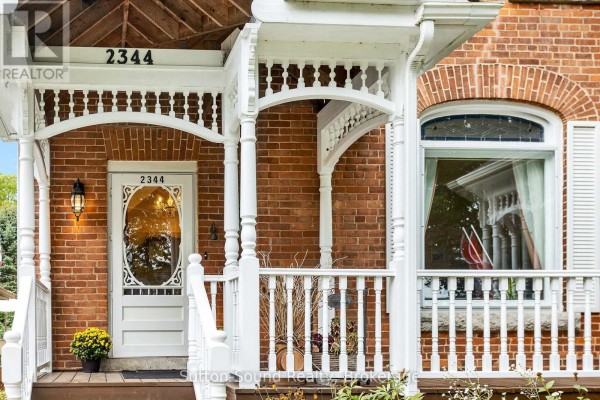 Entrance to the house with a white front door, porch railings, and brick facade. - 2344 3rd Avenue, Owen Sound
