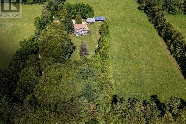 Aerial view of the house and surrounding snow-covered land with trees. - 234491 Concession 2 Wgr, West Grey