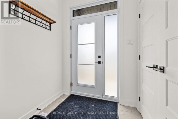 Frosted glass front door with coat rack and dark mat - 235 Bourdeau Boulevard The Nation