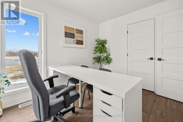 Modern office with white desk and chair, plant, window, and doors - 235 Bourdeau Boulevard The Nation