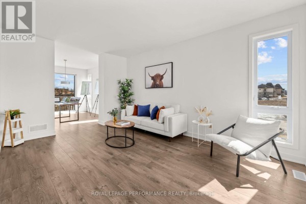 Modern living room with white sofa, accent chair, and large windows - 235 Bourdeau Boulevard The Nation