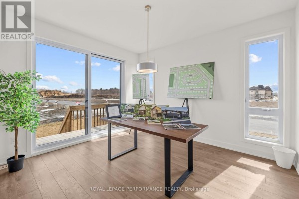 Architectural renderings and model home photos on display table - 235 Bourdeau Boulevard The Nation