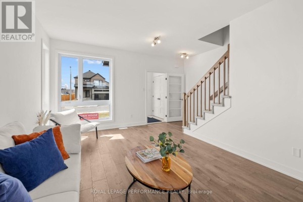 Living room with sofa, coffee table & staircase - 235 Bourdeau Boulevard The Nation