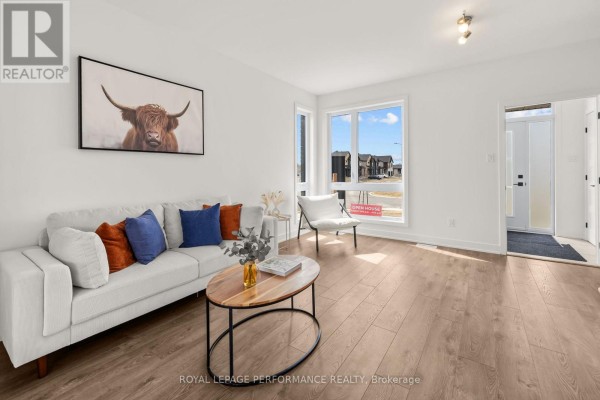 Living room with white sofa, oval coffee table, and artwork - 235 Bourdeau Boulevard The Nation