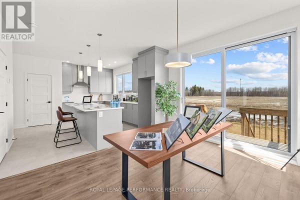 Modern kitchen island, pendant lights, and sliding glass door with views - 235 Bourdeau Boulevard The Nation