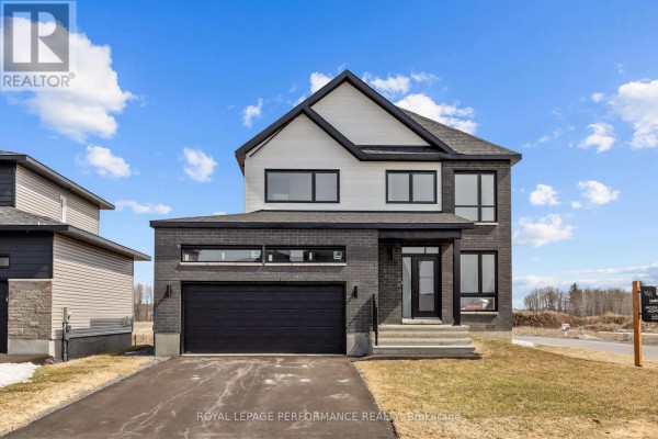 Modern home with dark brick and white siding, two-car garage - 235 Bourdeau Boulevard The Nation