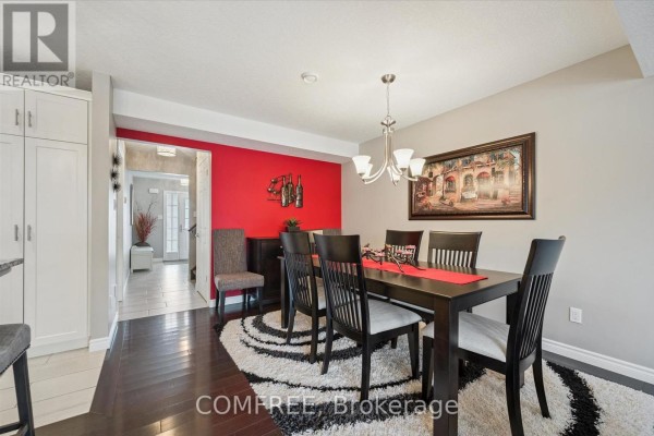 Modern kitchen with gray cabinets, stainless steel appliances, and island seating - 235 Spencer Drive, Centre Wellington