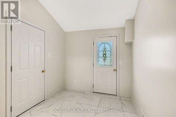 Interior entryway with white doors, a glass-paned front door, and marble-patterned tile floor. - 236 Campbell Drive N, Mcnab/braeside