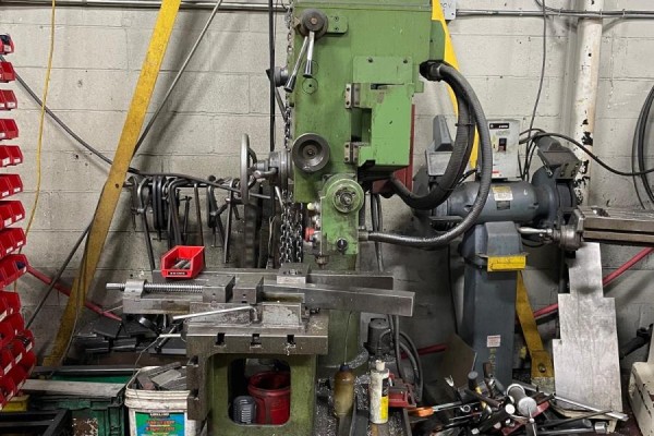 A green industrial drilling machine with tool racks, a grinder, and various metal parts. - 236 Canarctic Drive, Toronto