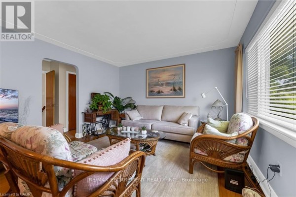 Dining room with light blue walls, wooden chairs, chandelier, and a glass display cabinet. - 236 Pine Cove Road, Burlington