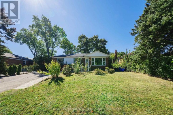 Front yard of a brick house with green grass, mature trees, and shrubs. - 236 Southview Road, Oakville