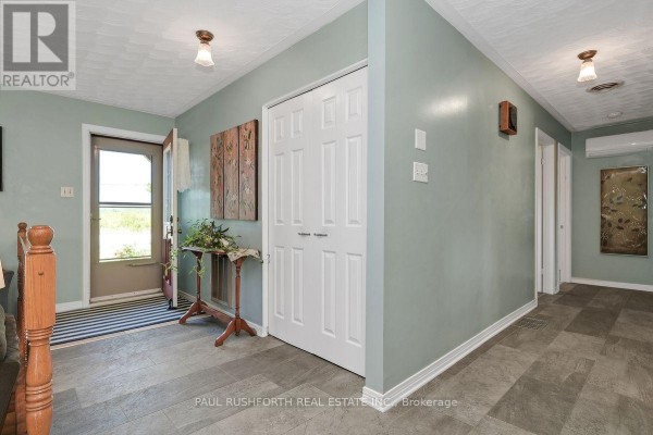 Interior hallway with light blue walls, a large white closet, and tile flooring. - 2362 Russland Road, Russell