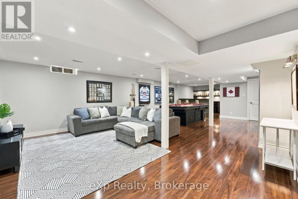 Finished basement with a sectional sofa, pool table, and bar area. - 237 Lake Driveway W, Ajax