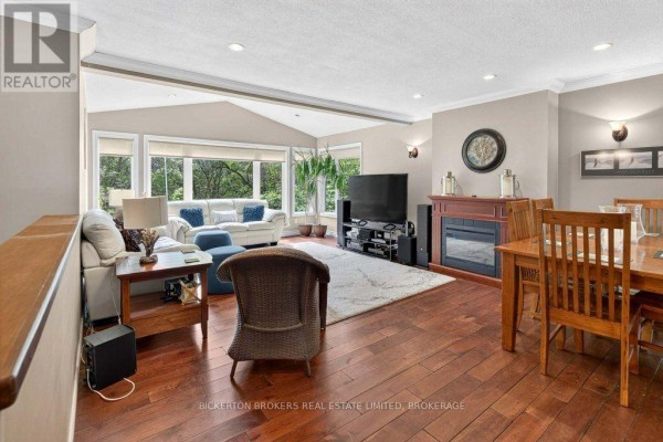 Living room with fireplace, sectional sofa, dining table, and large windows - 237 Old River Road Leeds And The Thousand Islands
