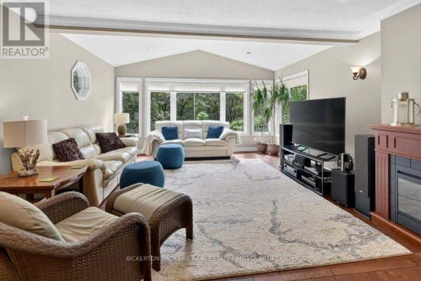 Living room with leather sofas, fireplace, and large windows - 237 Old River Road Leeds And The Thousand Islands