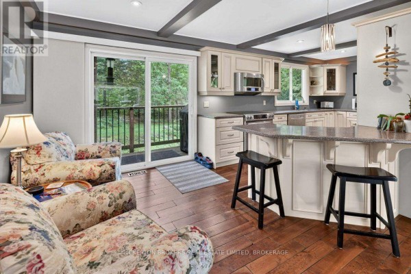 Kitchen with cream cabinets, granite counters, breakfast bar, and deck access - 237 Old River Road Leeds And The Thousand Islands