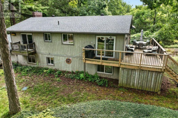 Rear exterior of the house showing a large wooden deck with railings and stairs. - 237 Old River Road, Leeds And The Thousand Islands