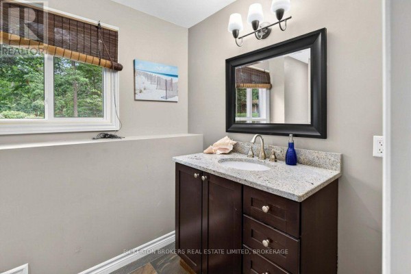 Bathroom vanity with granite countertop, dark wood cabinets, and large mirror - 237 Old River Road Leeds And The Thousand Islands